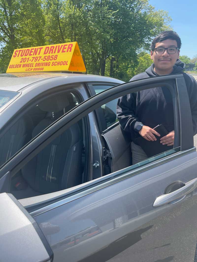 Student at the open door of a Golden Wheel Driving School car.