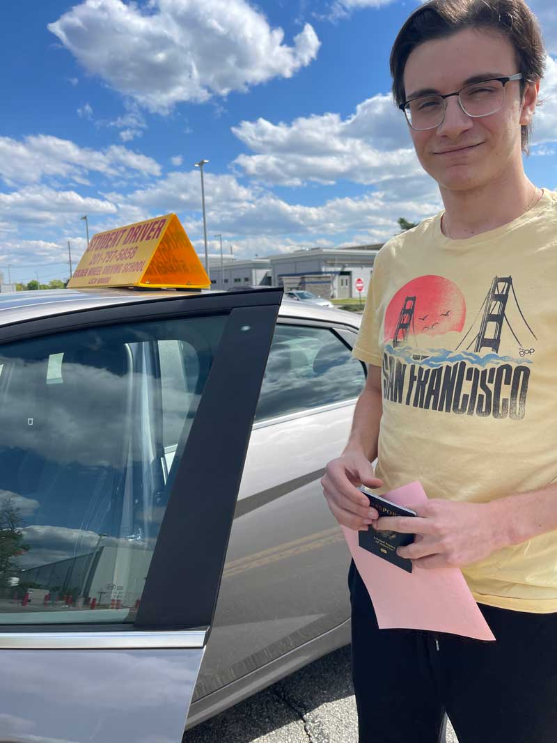 Student with a permit next to the Golden Wheel car on test day.